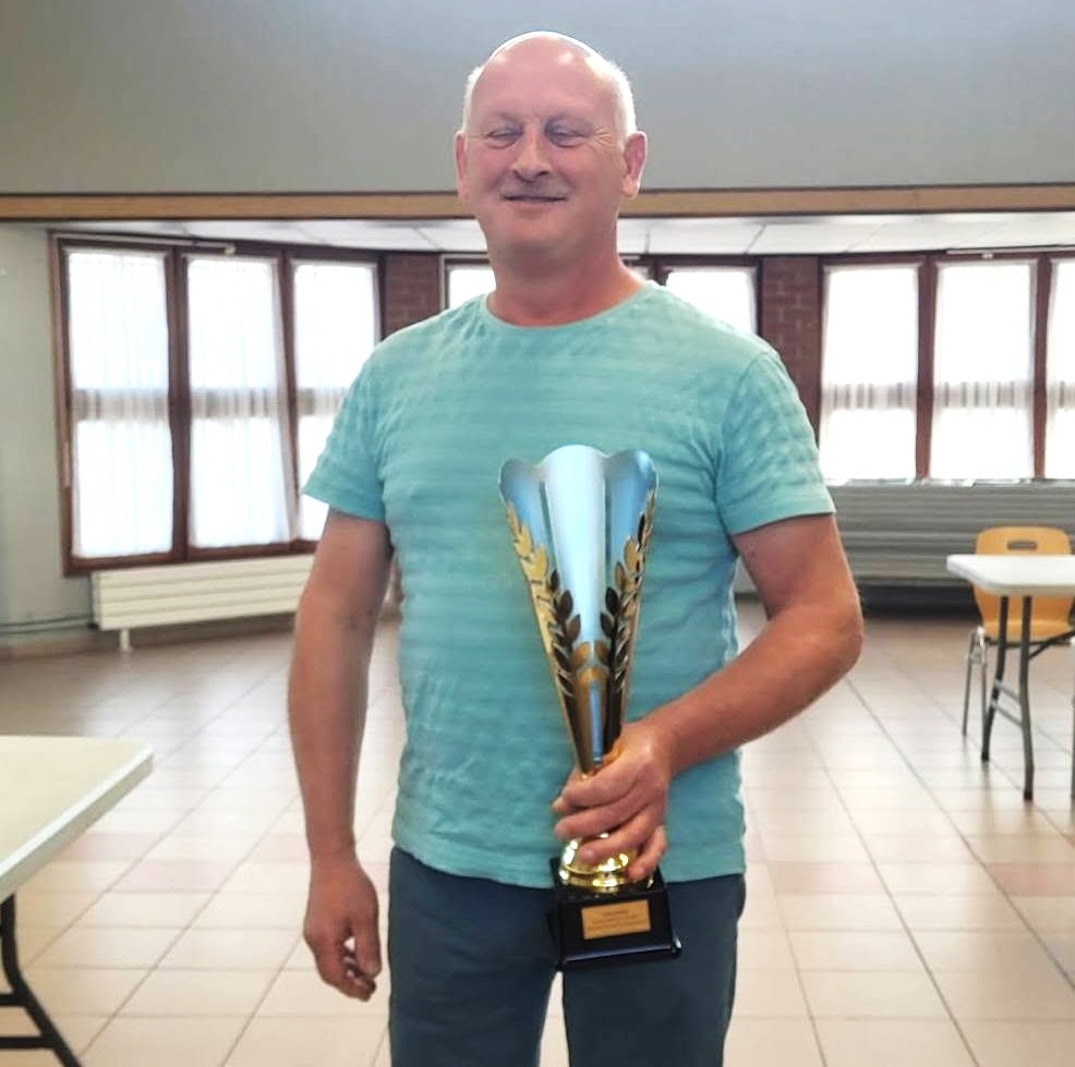 Dominique Brzozowski tenant un trophée.